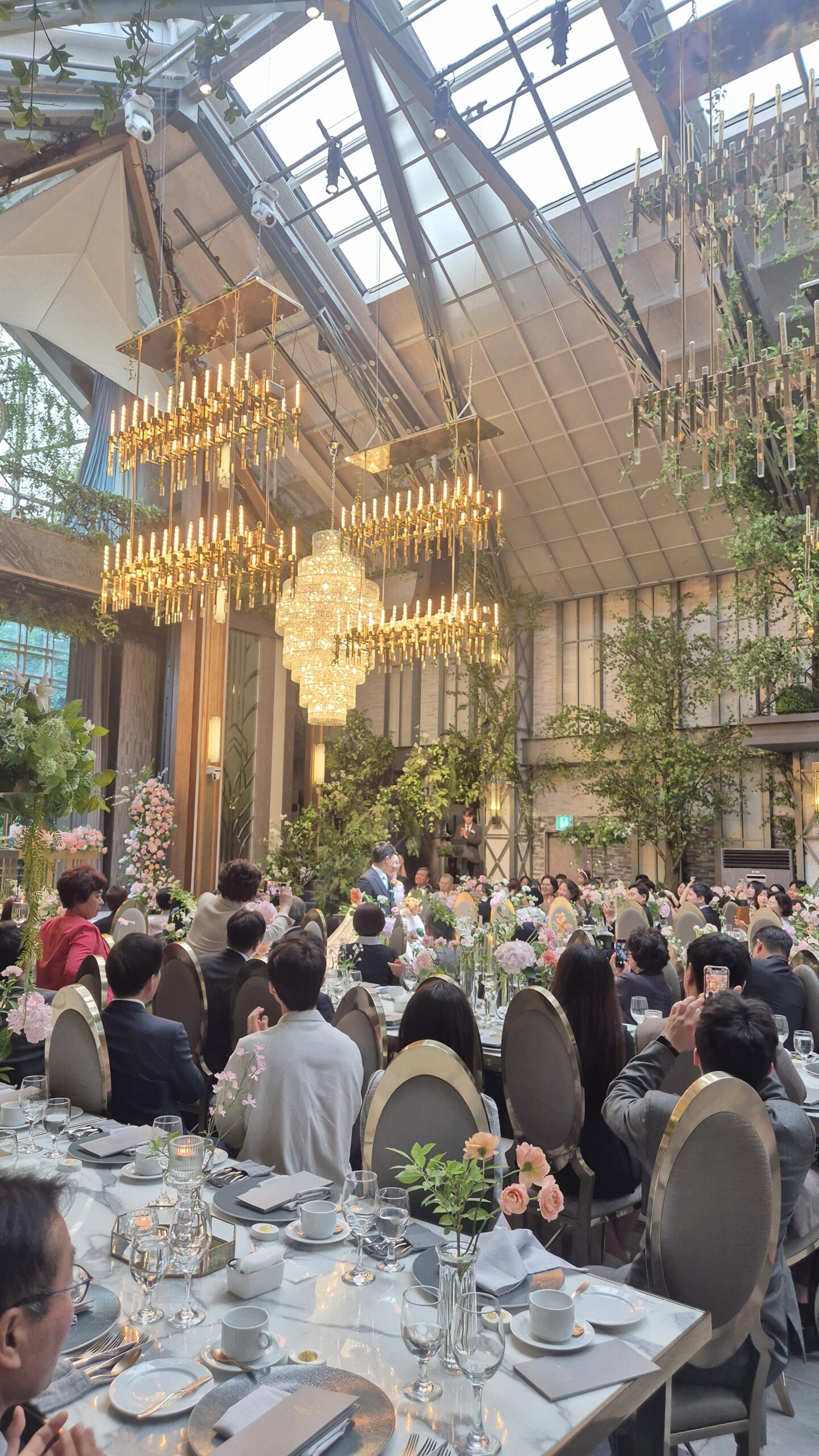Korean hotel wedding reception in greenhouse-style venue with gold chandeliers Seoul