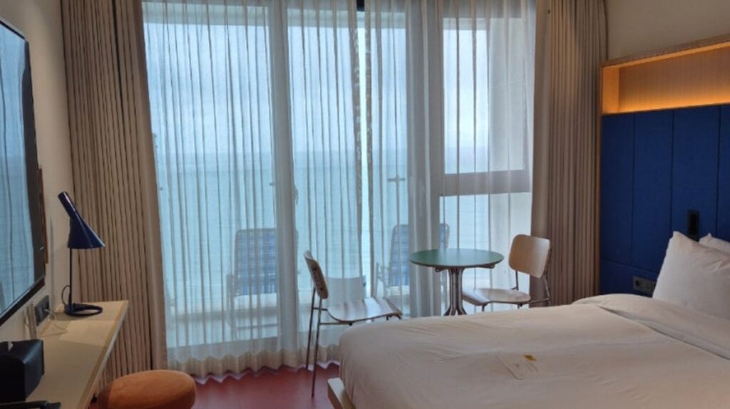 The Coolist Hotel Songjeong room with ocean view sheer curtains and designer chair