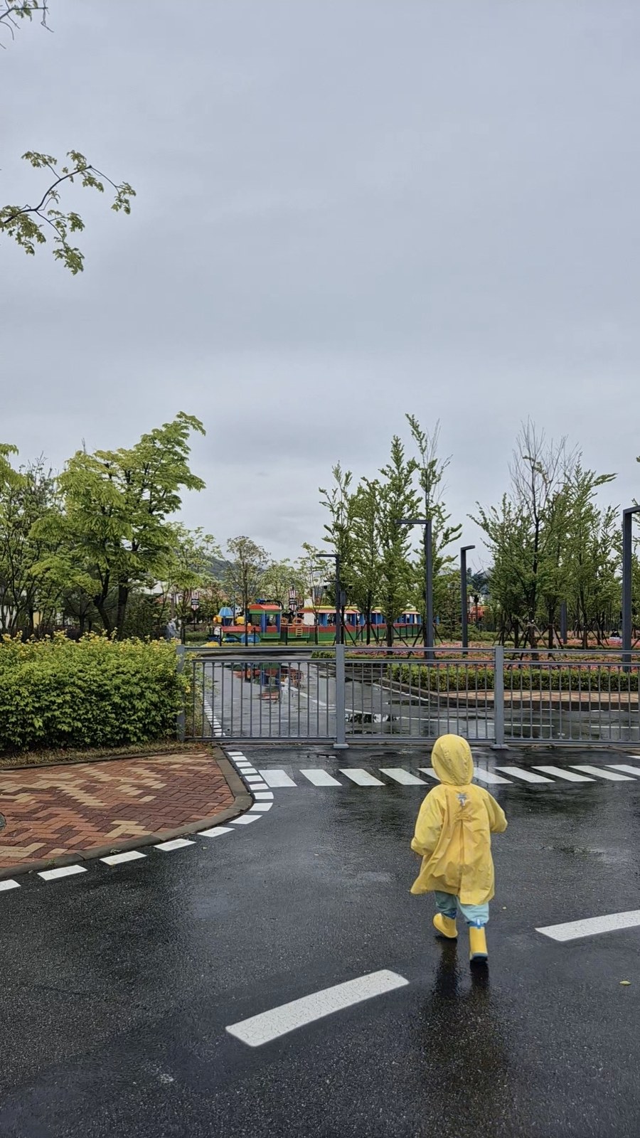 Young child in yellow raincoat at LegoLand Korea Chuncheon on a rainy day