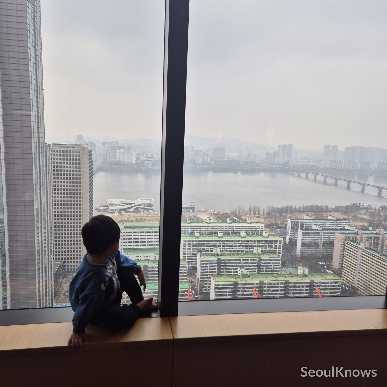 Baby looking out at the Han River view at Conrad Seoul