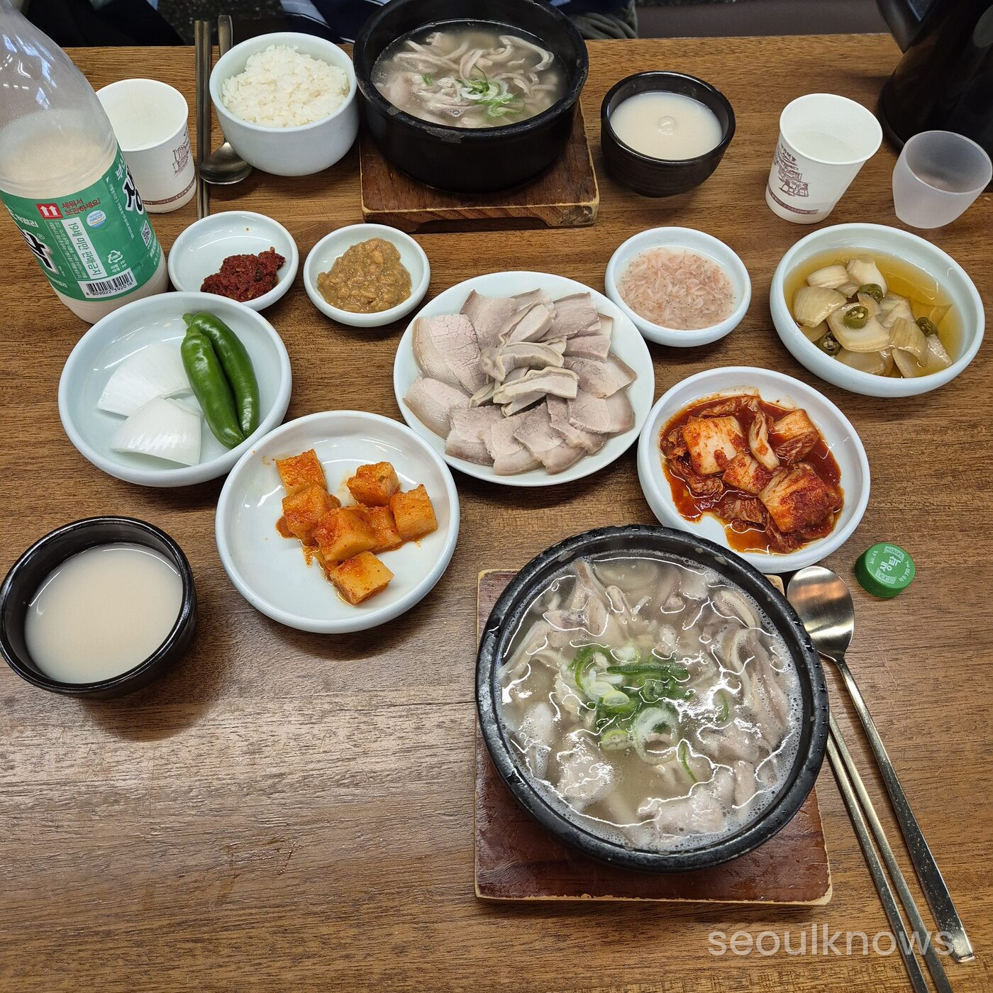 Full table set at Gukdong Dwaeji-Gukbap with two bowls, pork and banchan