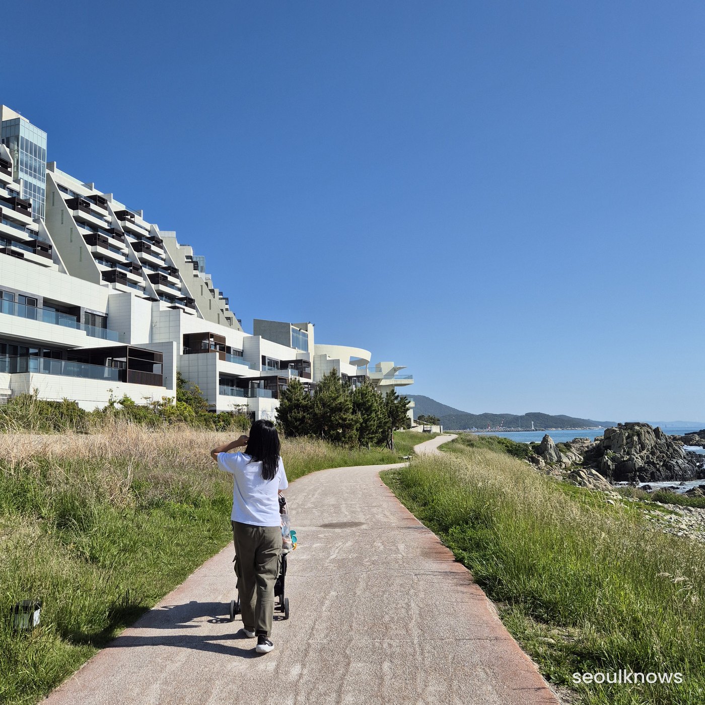 Coastal path with resort buildings at Ananti at Busan Cove