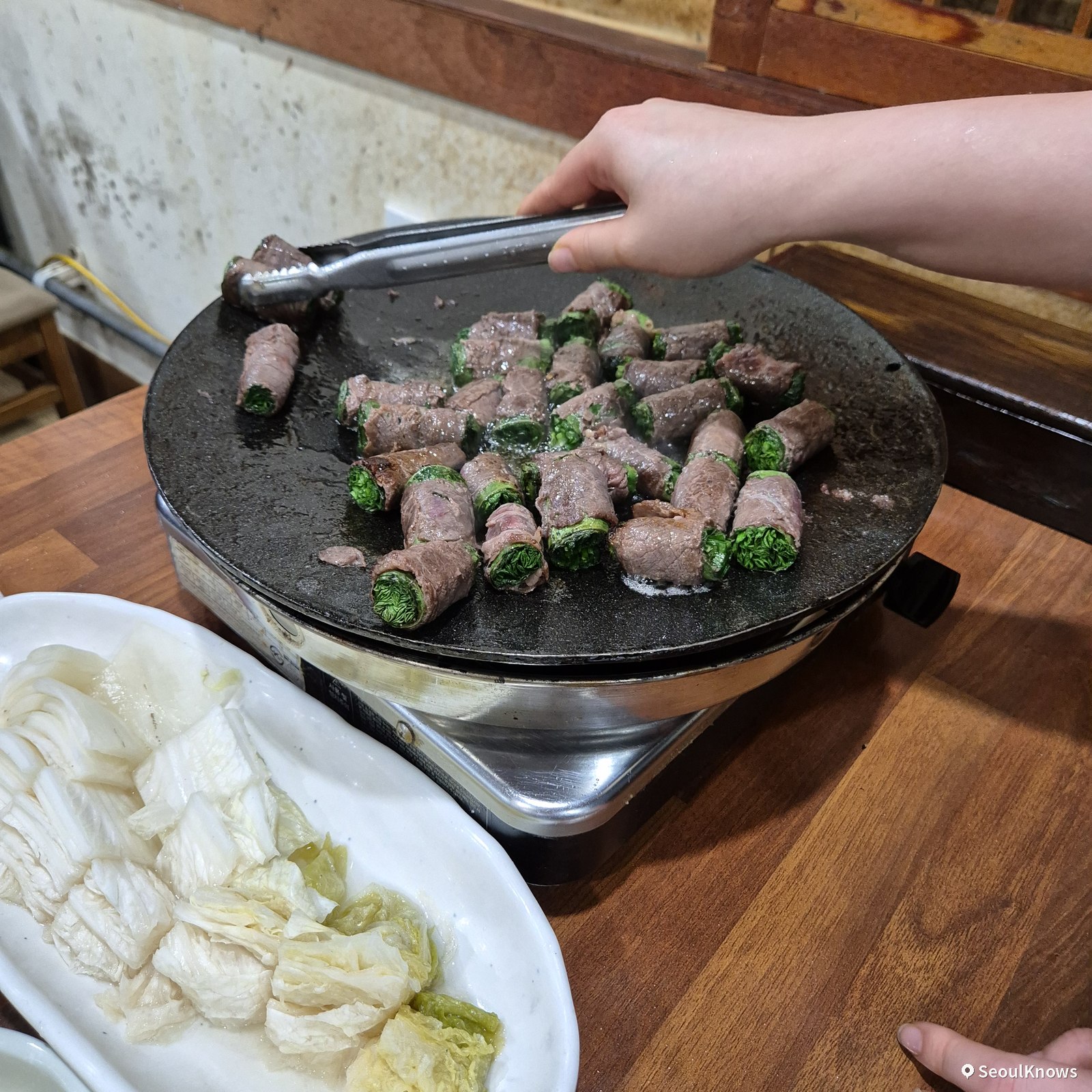 Staff grilling beef chive rolls table-side at Asura Busan