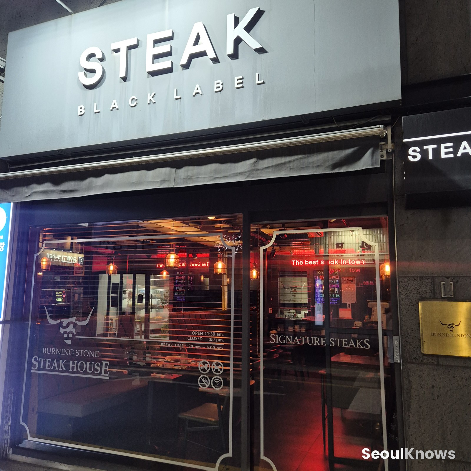 Burning Stone STEAK Black Label signage at night