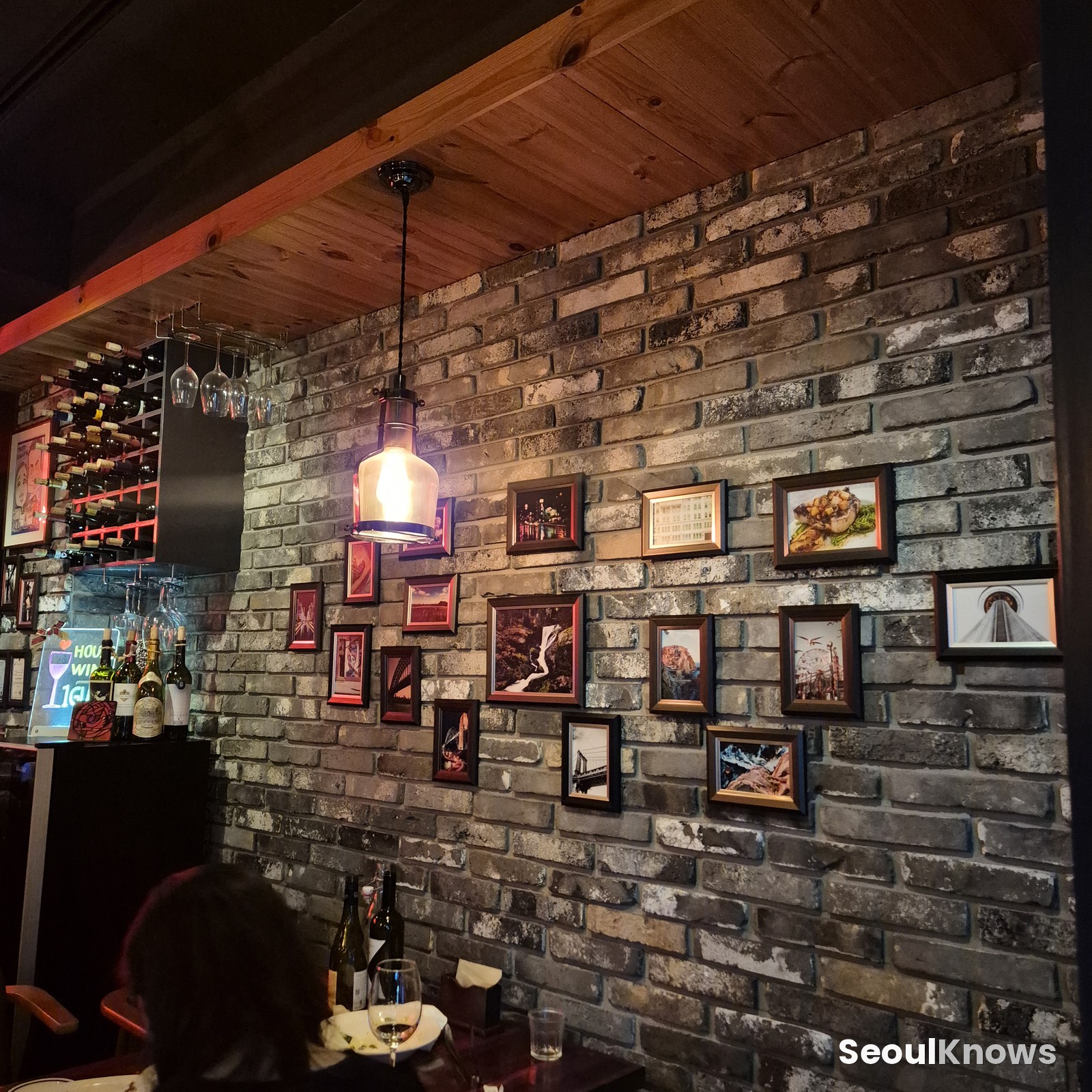 Exposed brick wall with framed prints at Burning Stone