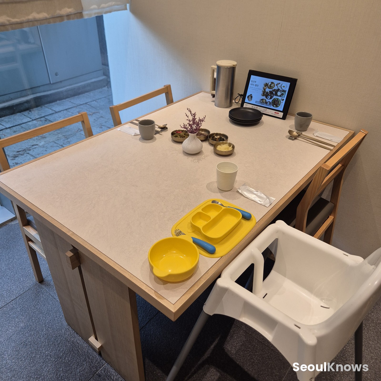 Private room with a set table and a high chair for a toddler
