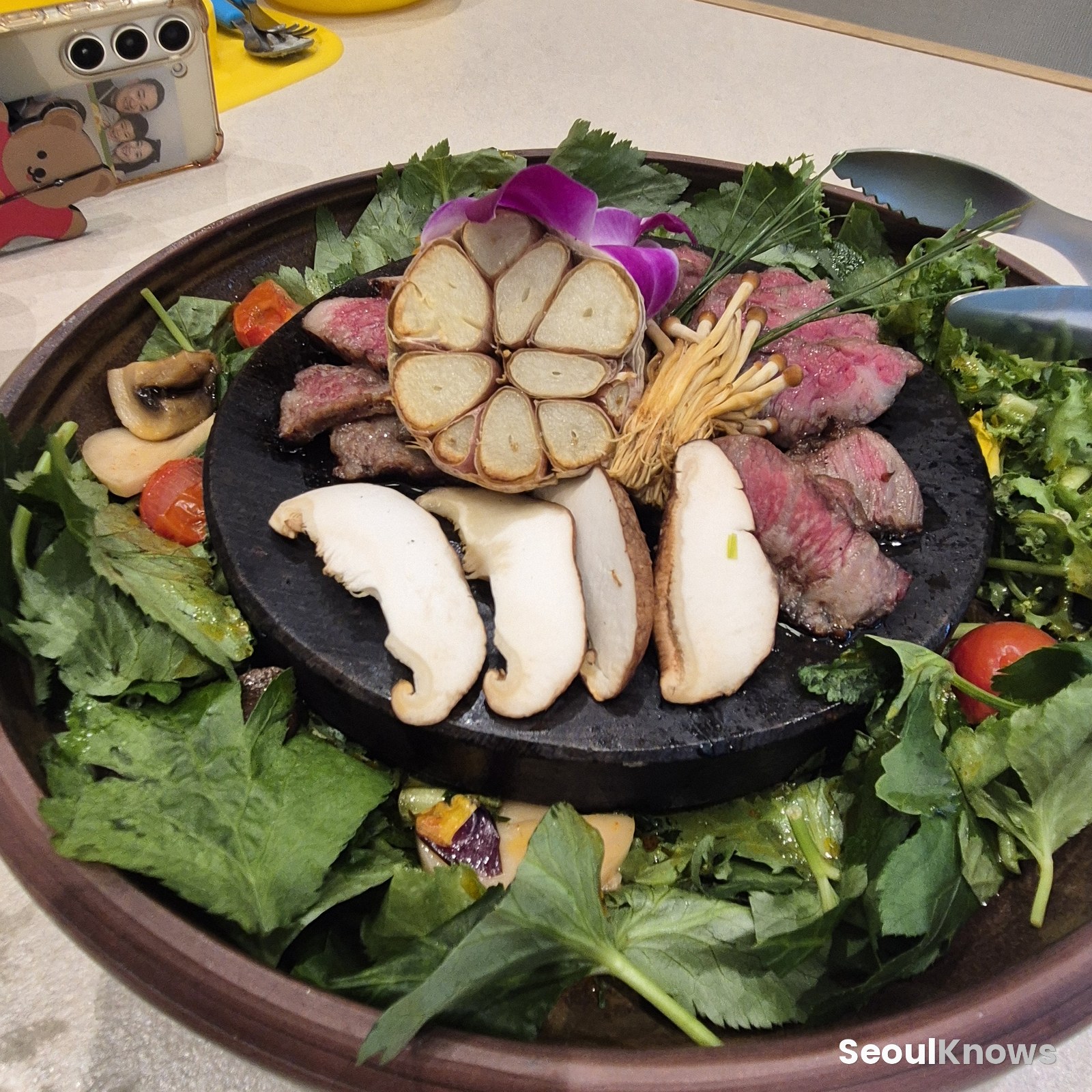 Yeonhyang marinated galbi grilled on a stone plate with mushrooms and garlic