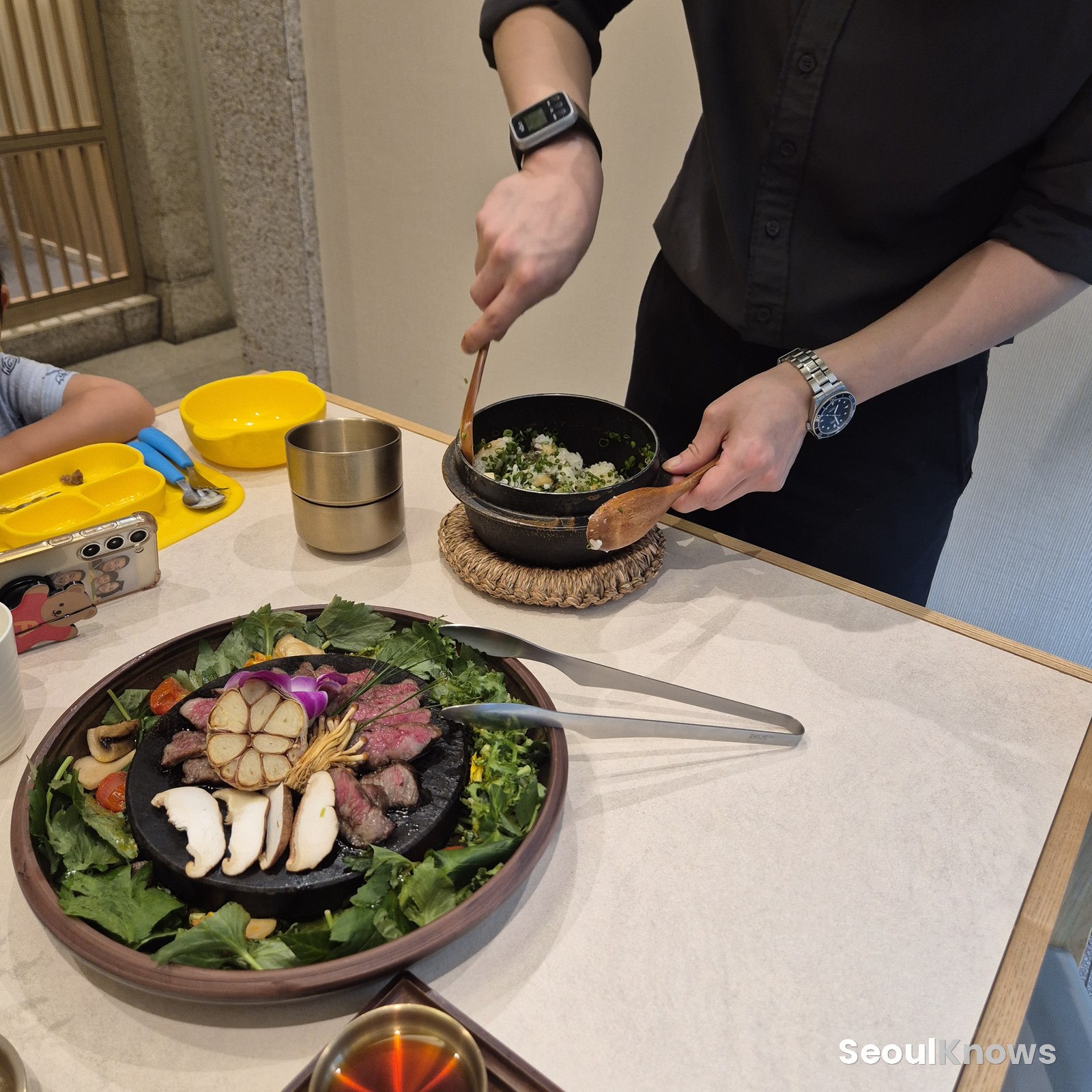 Staff mixing and portioning the clay-pot rice at the table