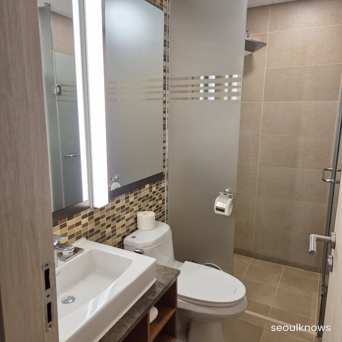 Clean tiled bathroom with sink, toilet and shower