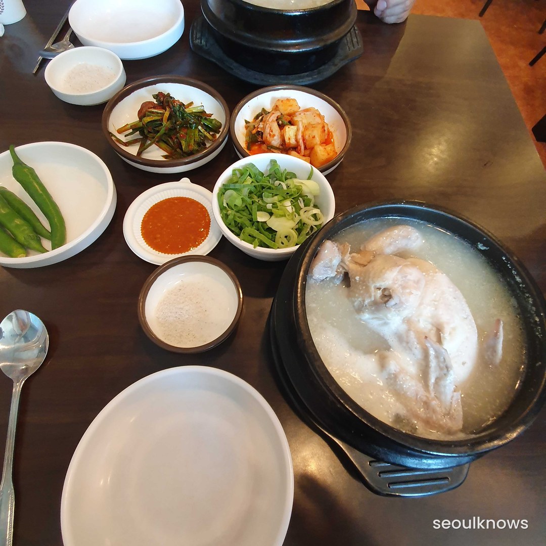 Samgyetang served with kimchi and banchan side dishes