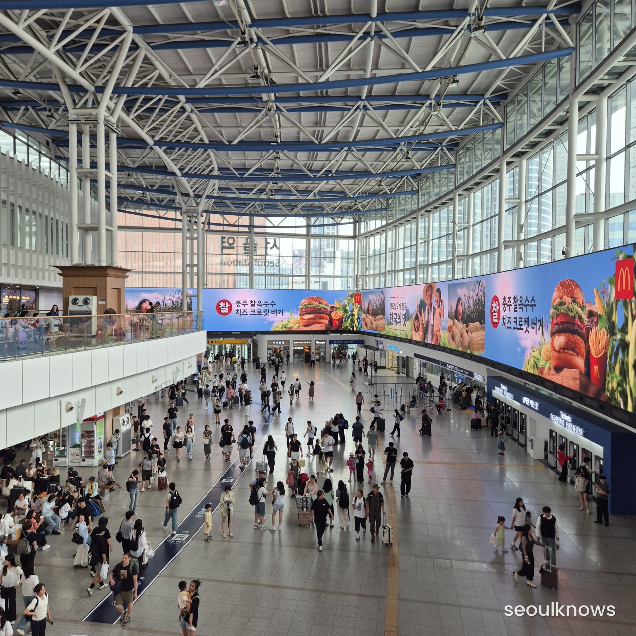 Seoul Station main concourse with travelers and departure boards