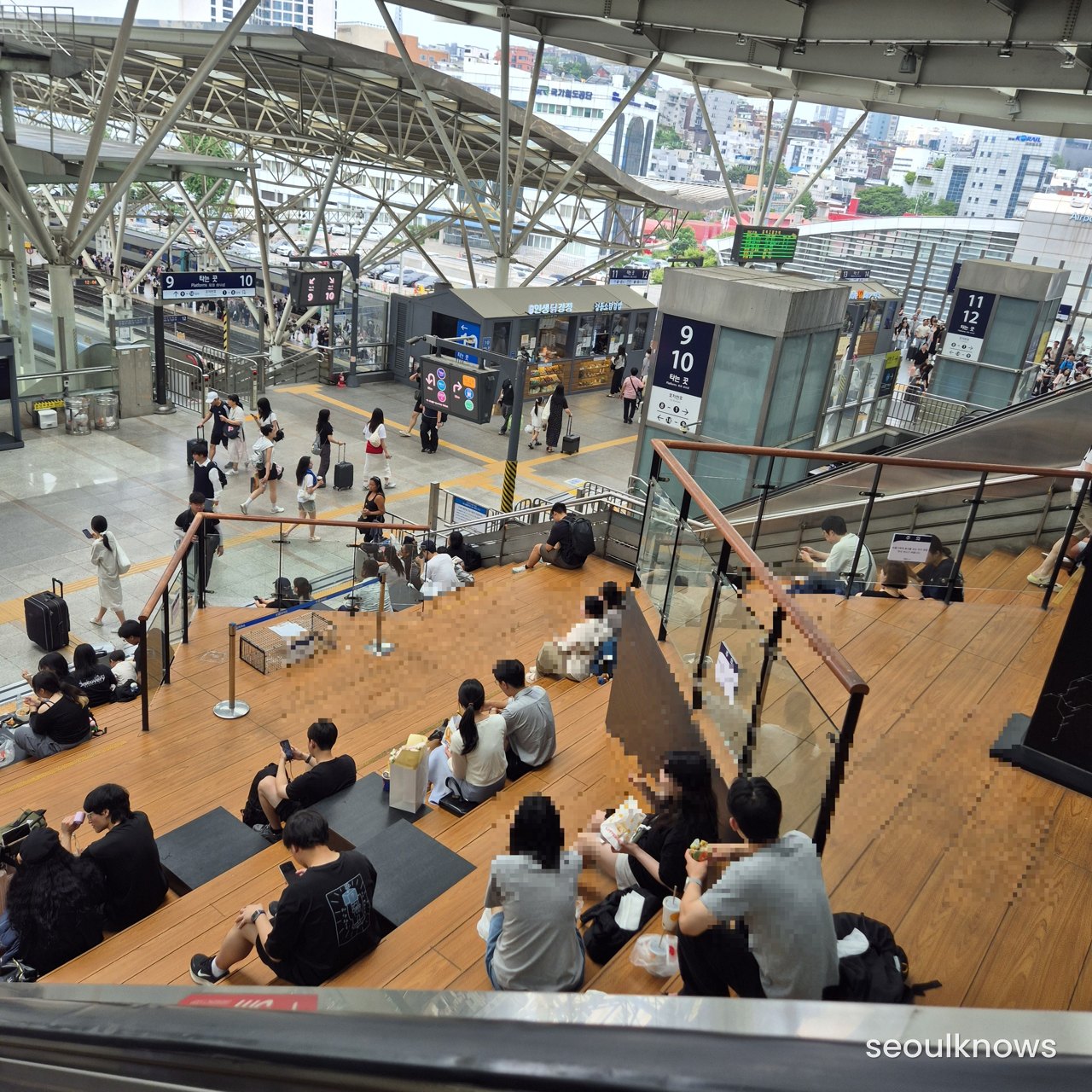The wide staircase inside Seoul Station where people sit and wait