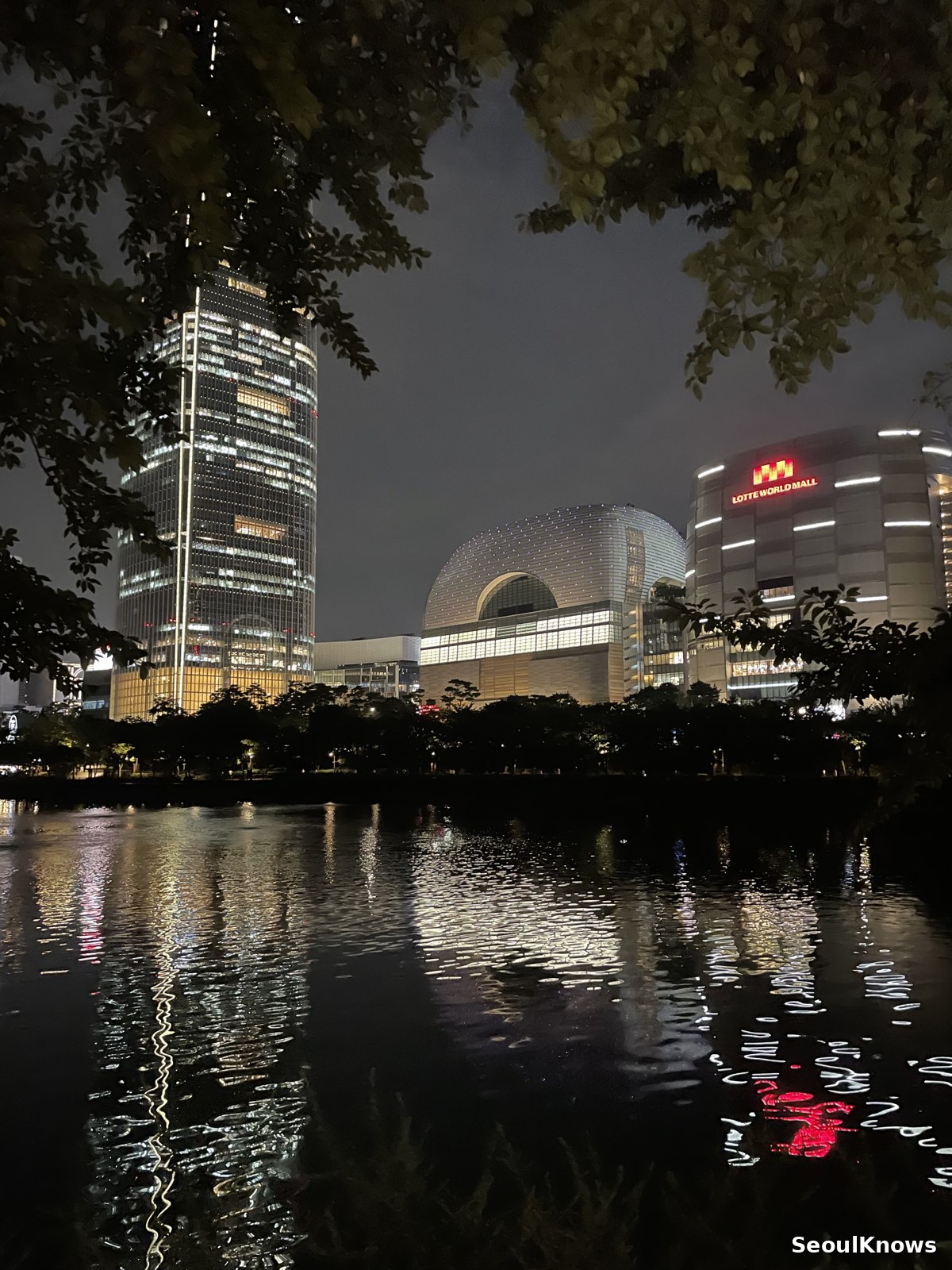 Seokchon Lake at night with city lights reflected in the water
