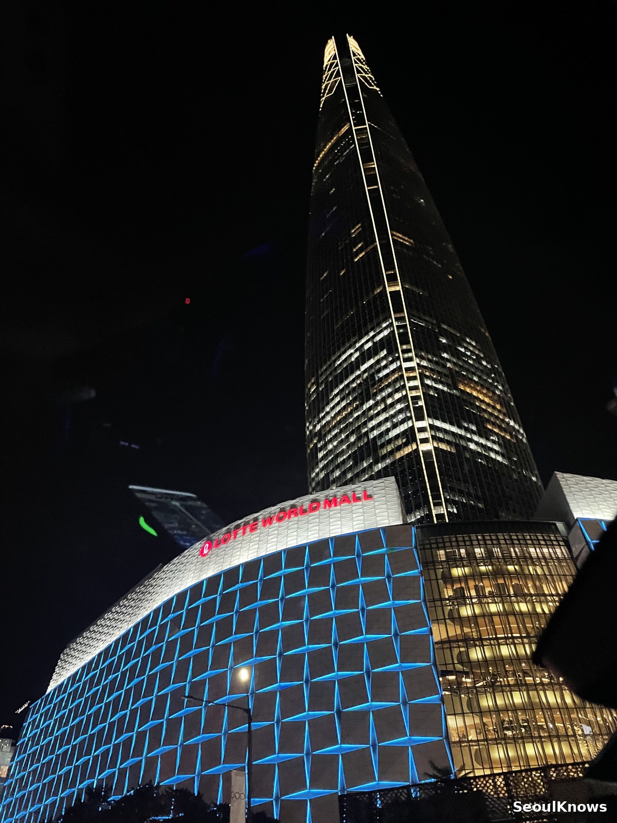 Lotte World Tower and mall lit up at night in Jamsil