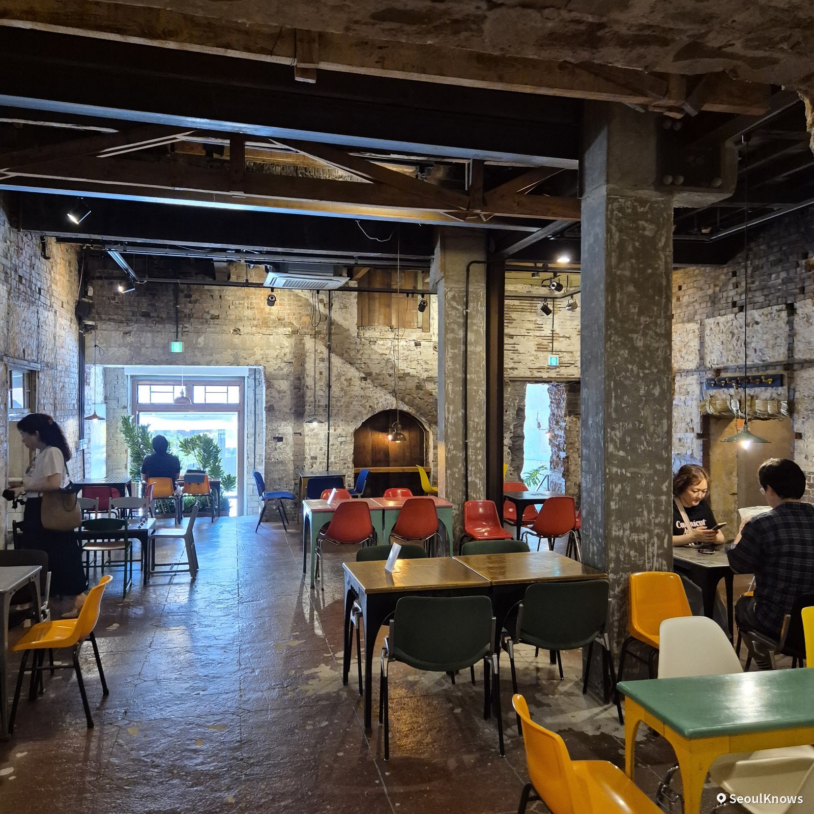 Wide view of colorful seating inside Brown Hands Baekje cafe