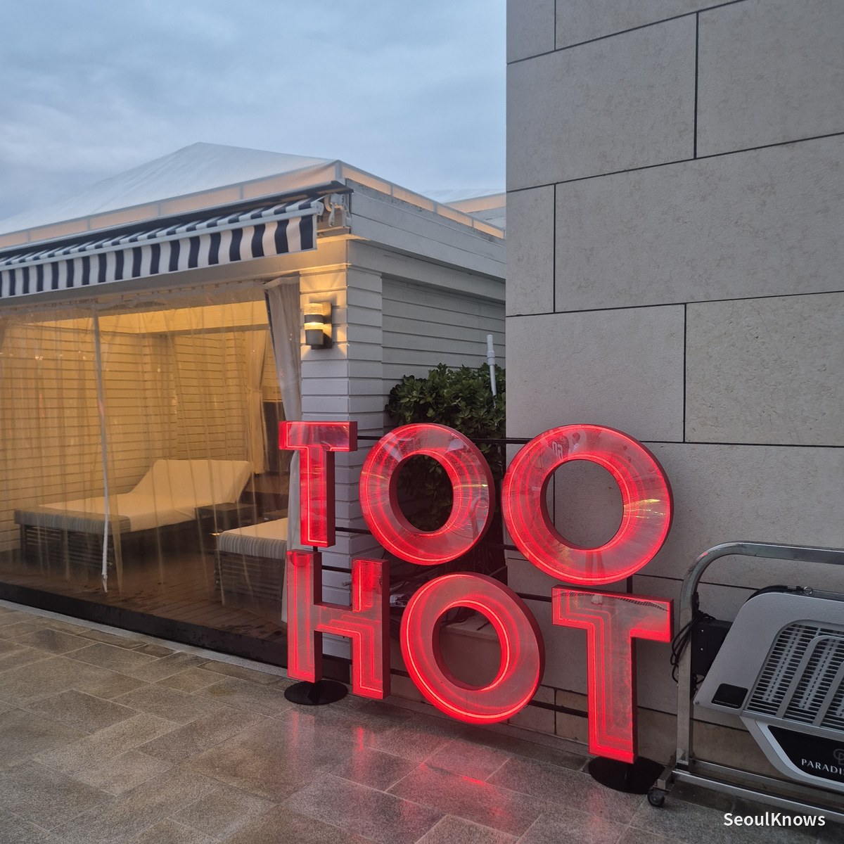 TOO HOT neon installation beside a cabana at Cimer pool party