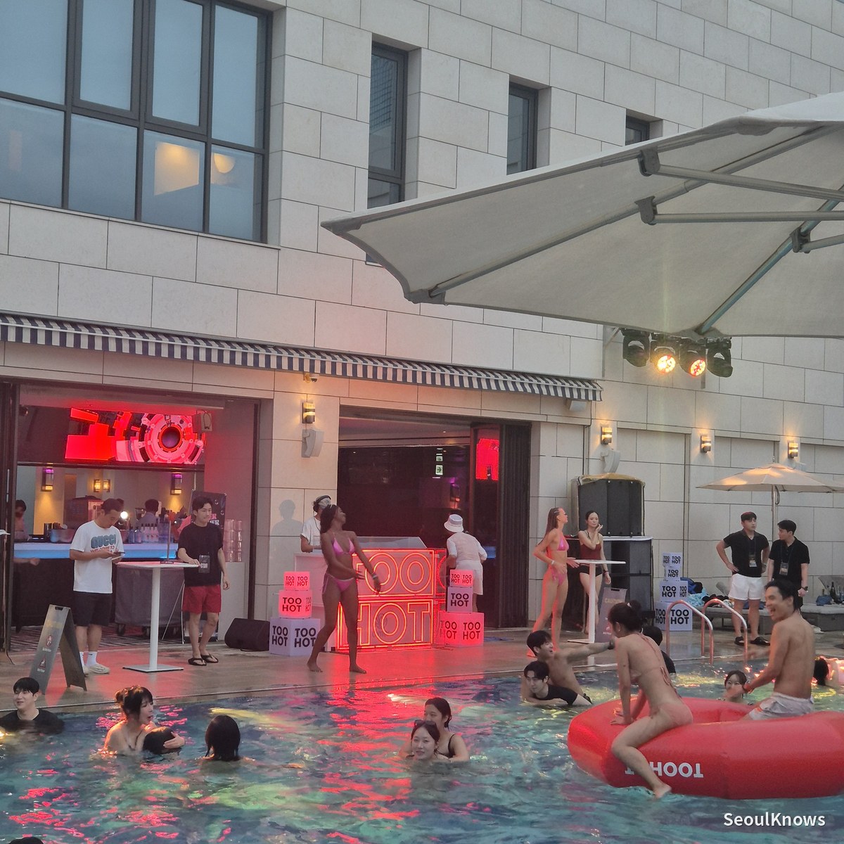 Cimer outdoor pool at dusk with the TOO HOT booth and DJ stage