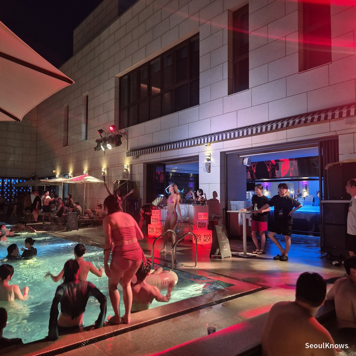 Crowd gathered in front of the poolside stage at night