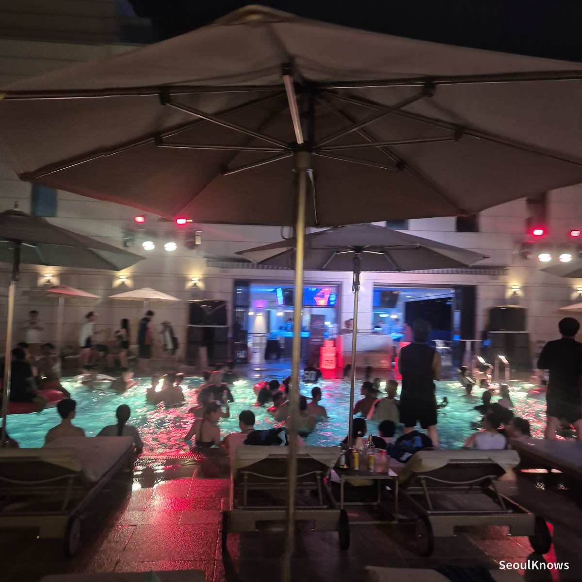 Cimer outdoor pool at night seen from under a poolside parasol