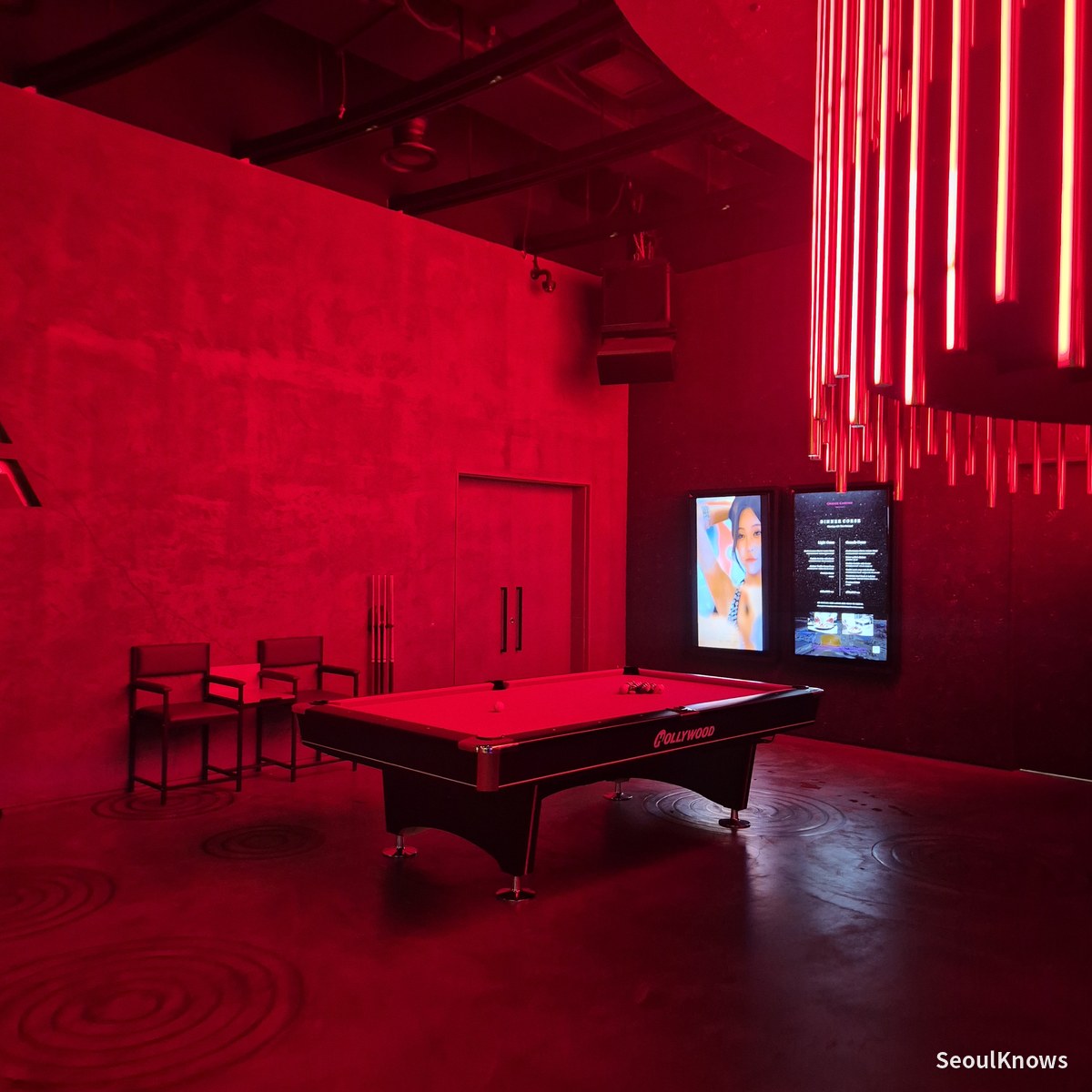 Pool table in a red-lit room inside Club Chroma