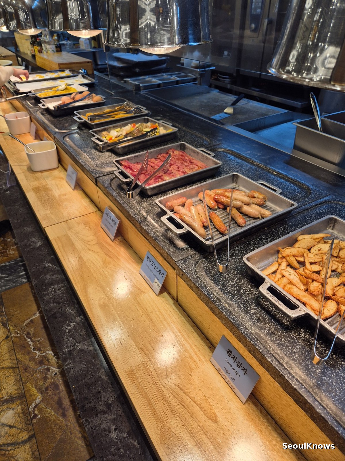 Warm buffet counter with sausages and fried items at Hotel Susung breakfast