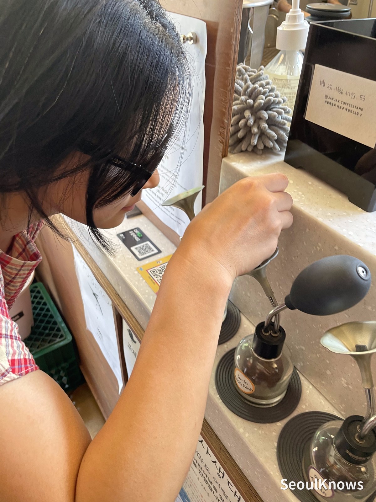 Pressing the rubber bulb to smell a coffee bean at Jakjak Coffee Stand