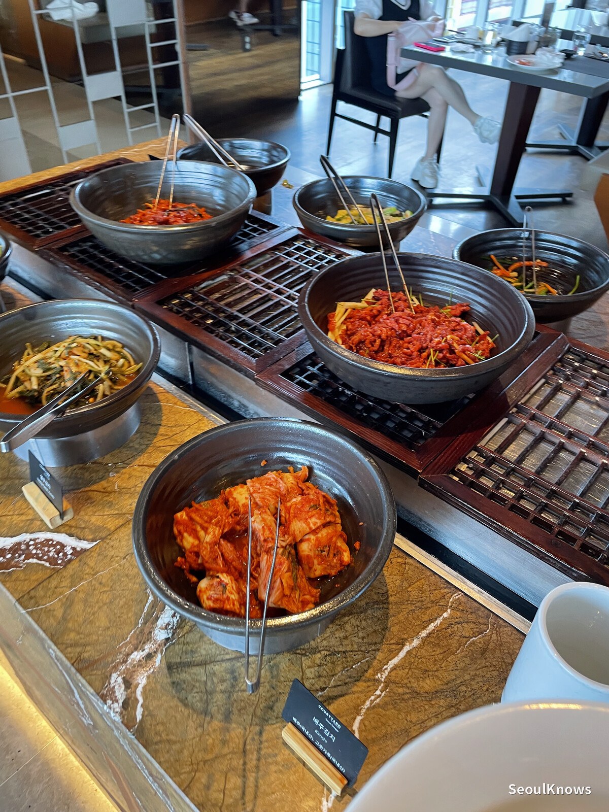Korean side dishes including kimchi and seasoned vegetables at MoMo Cafe