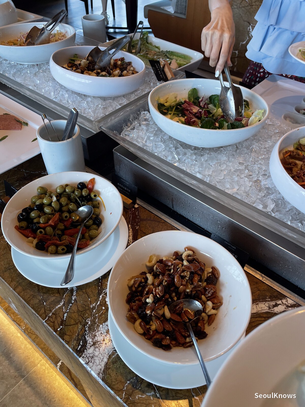 Salad, olives and pickles laid out on ice at MoMo Cafe