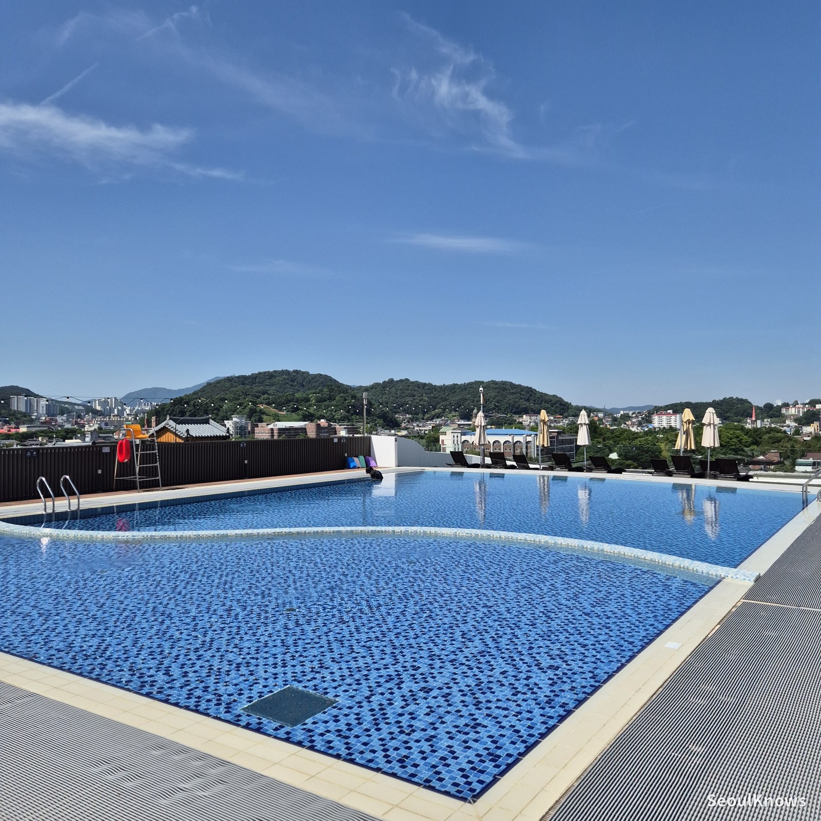 Rooftop pool with hanok village and mountain view