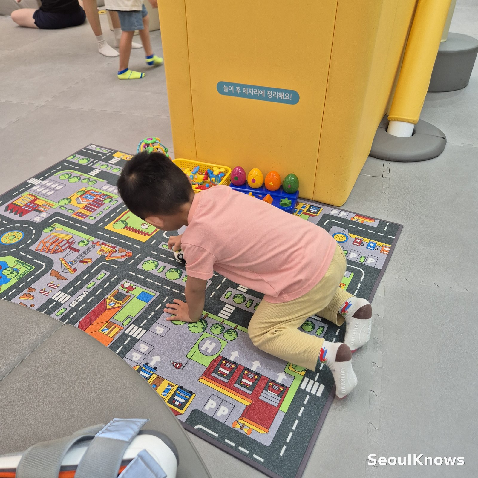 Toddler playing with cars on a road mat at Dogok indoor playground