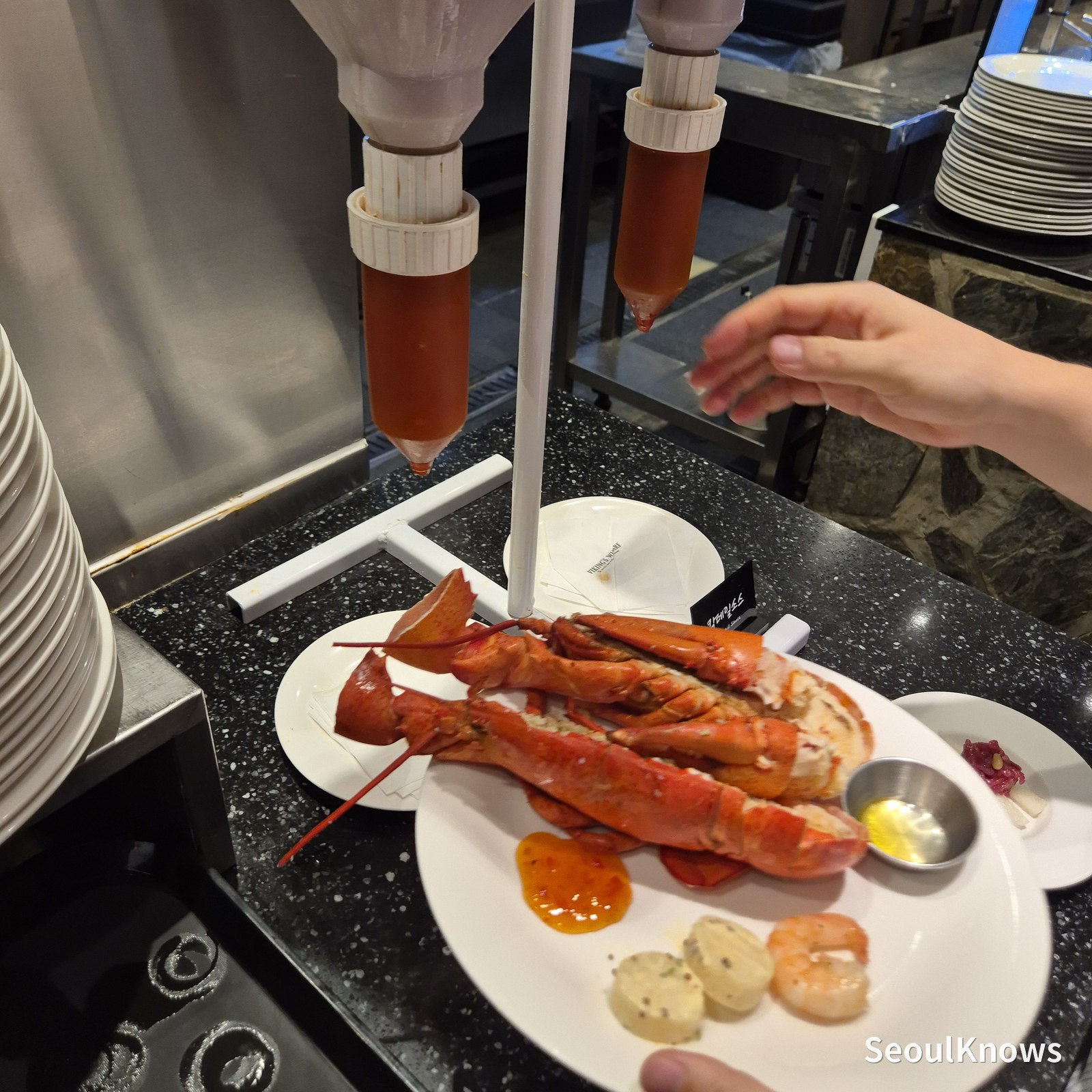Melted butter dispenser beside a plate of lobster at Viking's Wharf COEX