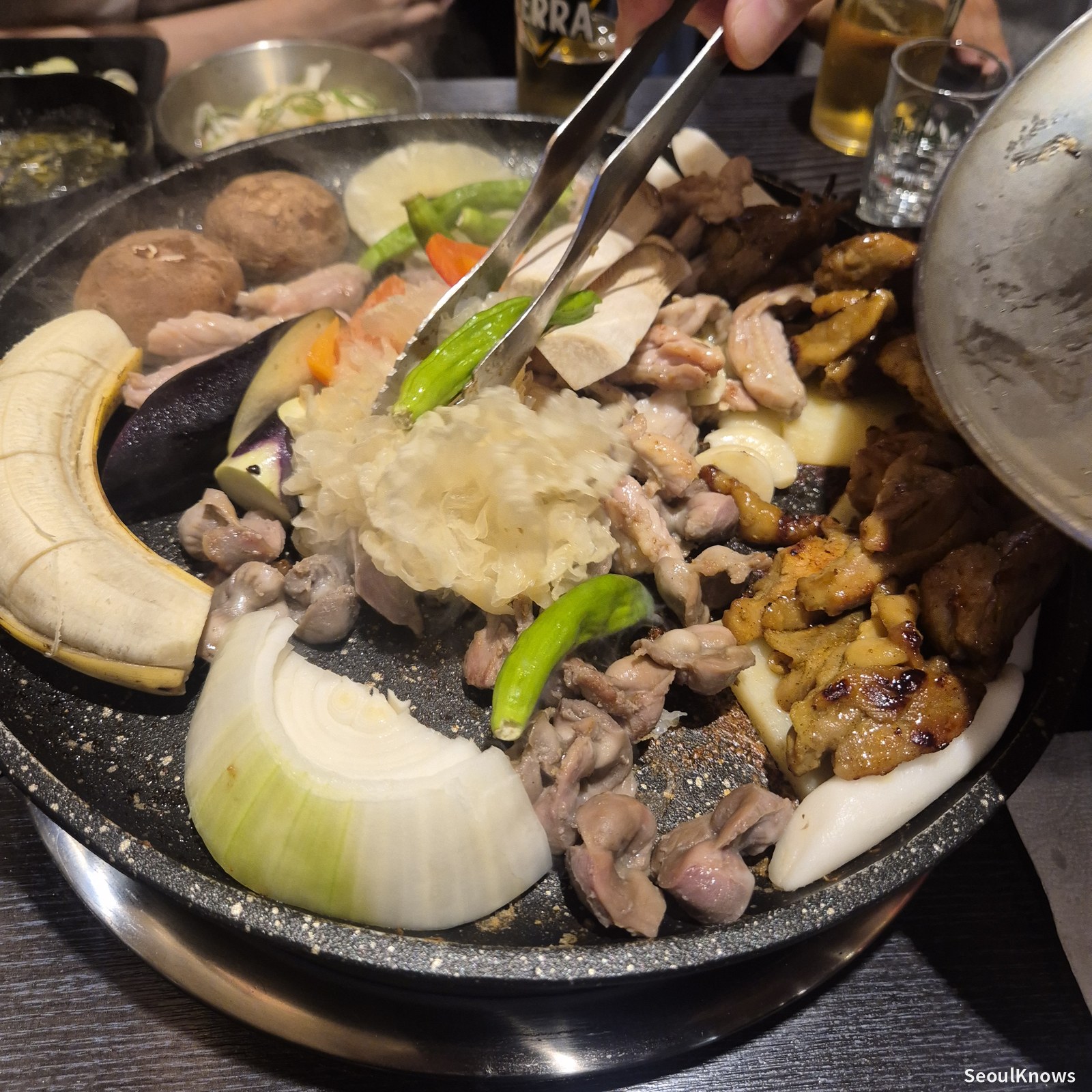 Staff grilling chicken galbi with banana and onion at Wolgyerang