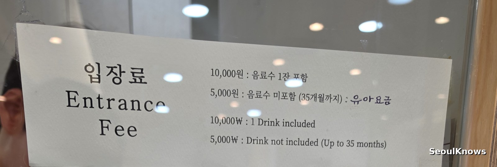 Entrance fee board at a Korean cat cafe showing 10,000 won including one drink