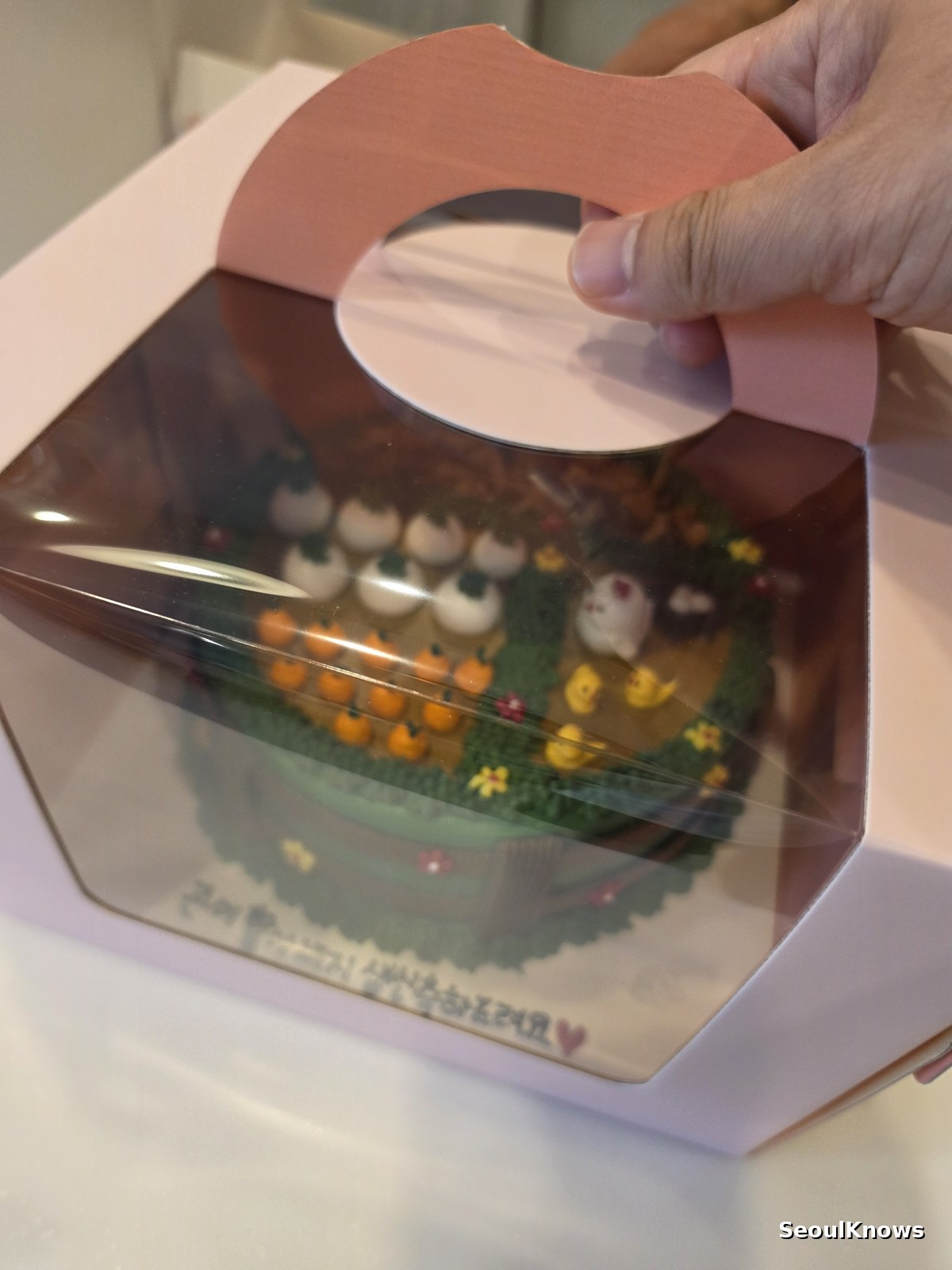 Custom cake packed in a clear window box for transport in Seoul
