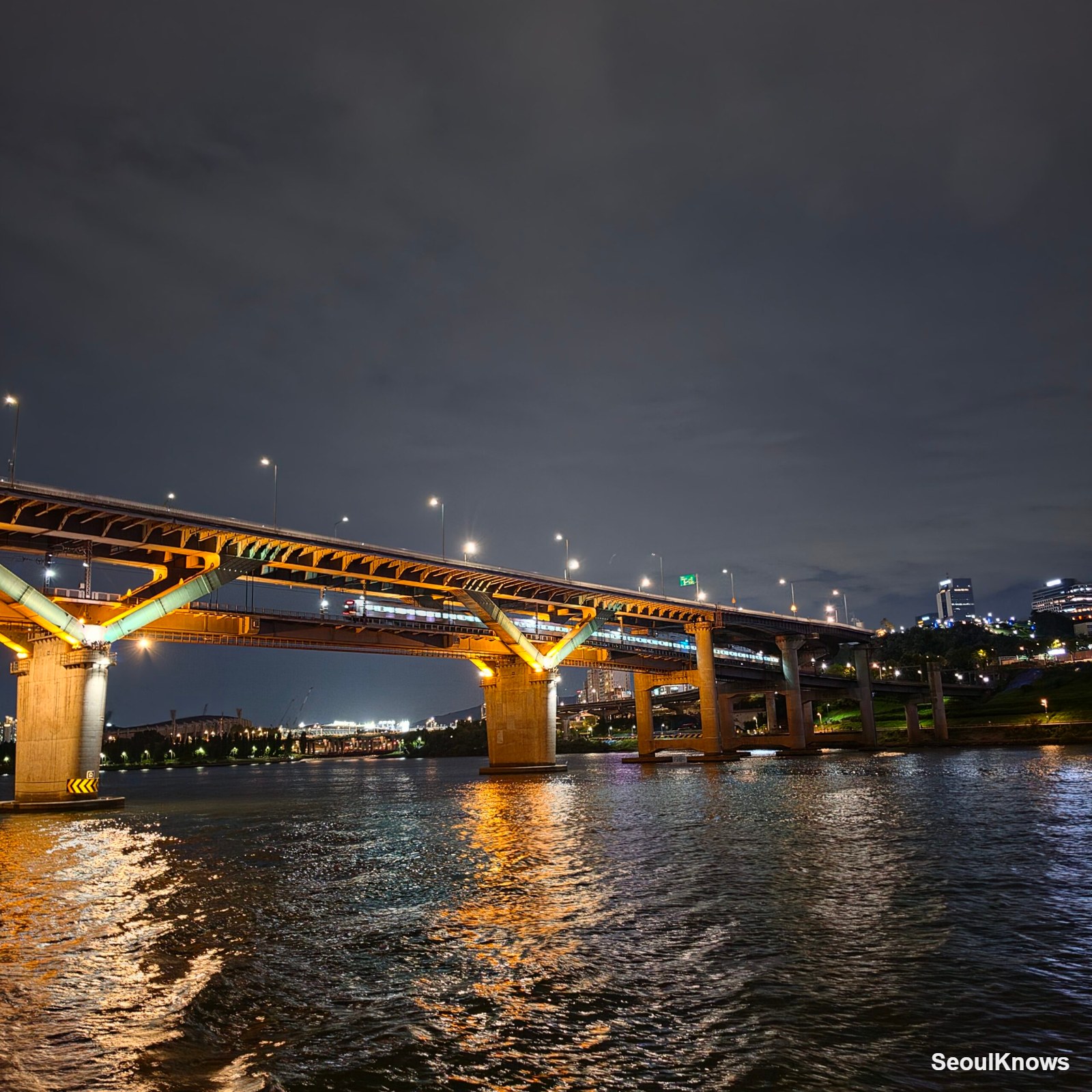 Passing under a lit Han River bridge on a night cruise in Seoul