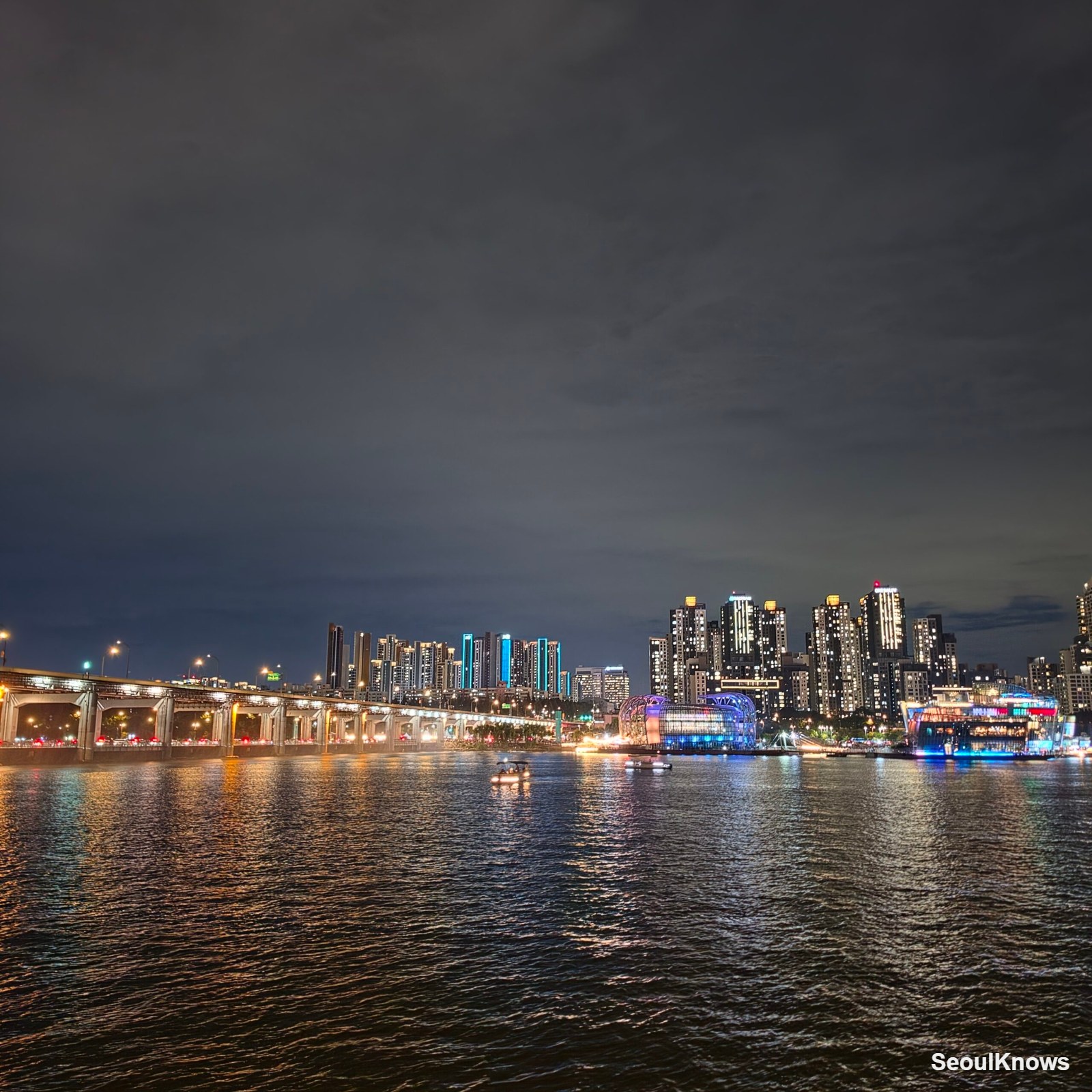 City lights reflected on the Han River at night from the cruise deck