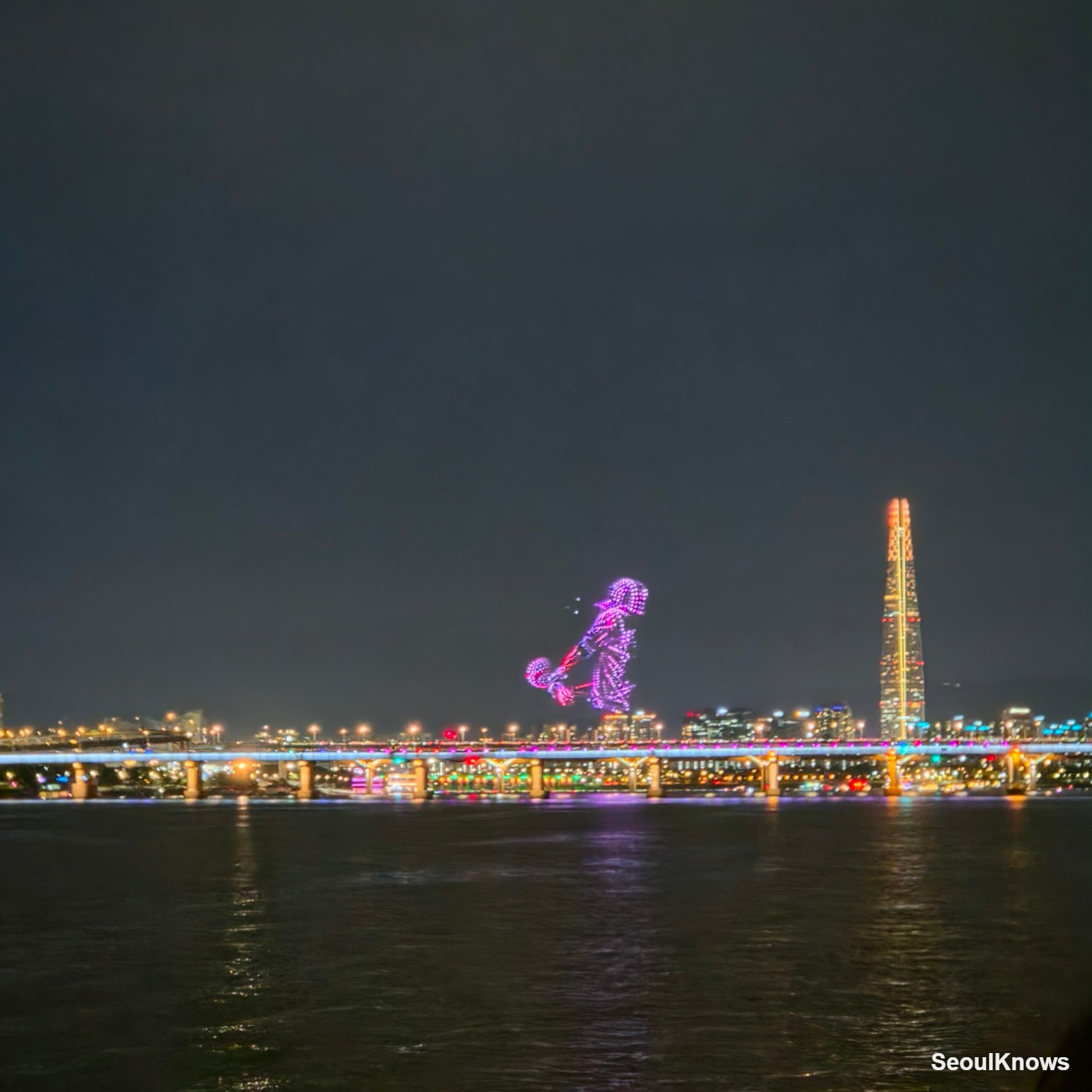 Drone light show forming a figure over the Seoul skyline at night