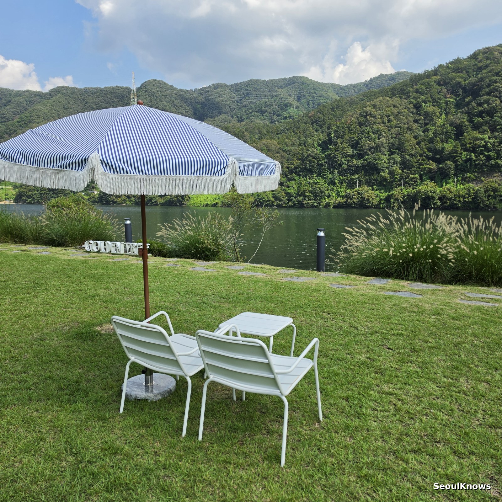 Parasol and outdoor seating on the riverside lawn at Golden Tree Gapyeong