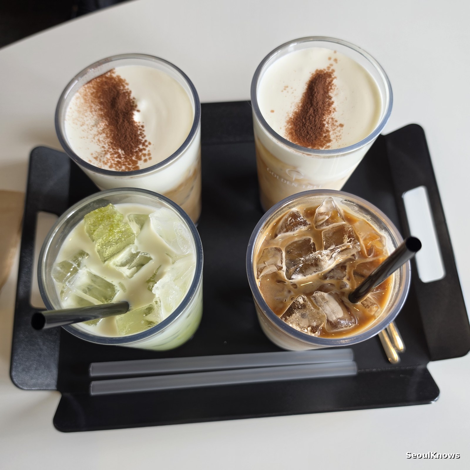 Signature cream lattes green tea latte and iced coffee on a tray at Golden Tree
