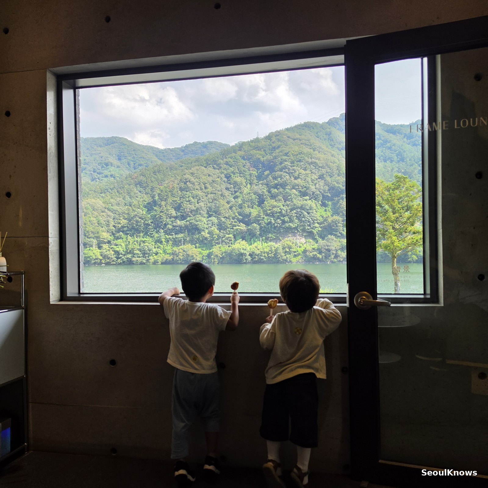 Children watching boats through the window at Golden Tree cafe in Gapyeong