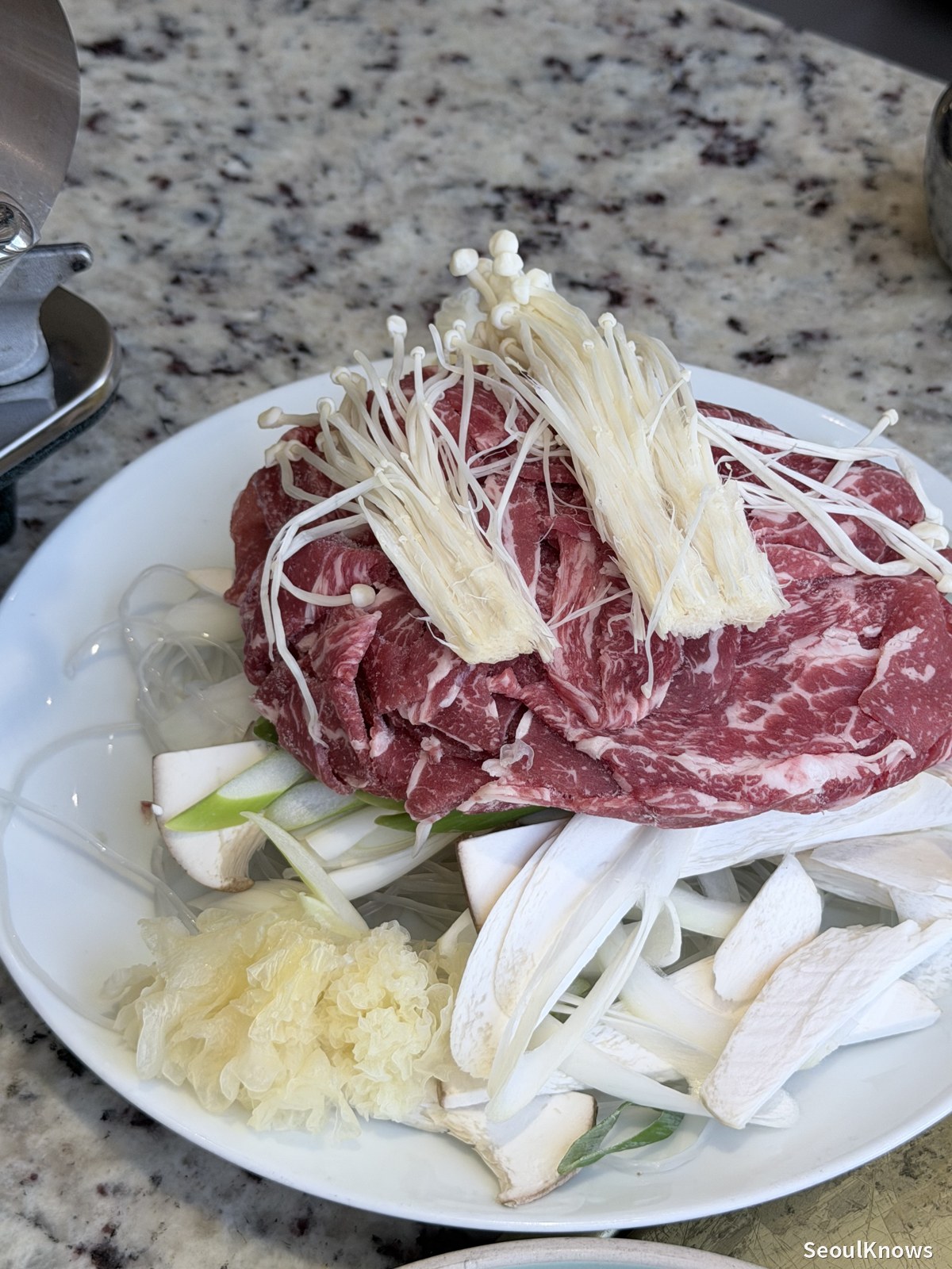 Hanwoo beef with enoki and king oyster mushrooms in the pan